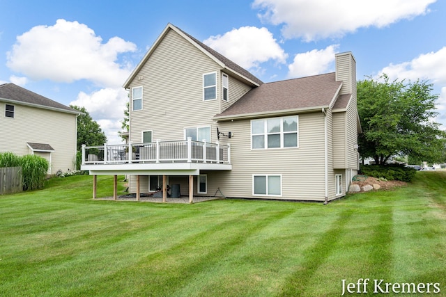 5692 Nile Dr SW, Wyoming, MI 49418 - rear view of property featuring a chimney, a wooden deck, a lawn, and a shingled roof
