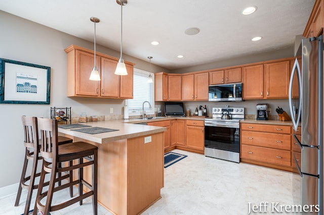 5692 Nile Dr SW, Wyoming, MI 49418 - kitchen featuring stainless steel appliances, a peninsula, recessed lighting, light countertops, and hanging light fixtures