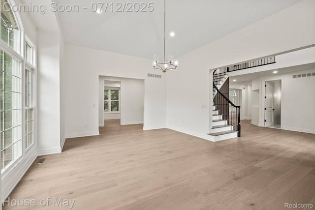 4743 S Ridge Dr, West Bloomfield, MI 48323 - empty room with a high ceiling, a chandelier, stairs, light wood-style flooring, and recessed lighting