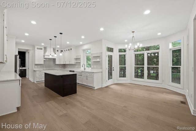 4743 S Ridge Dr, West Bloomfield, MI 48323 - kitchen featuring premium range hood, recessed lighting, white cabinetry, a chandelier, and decorative backsplash
