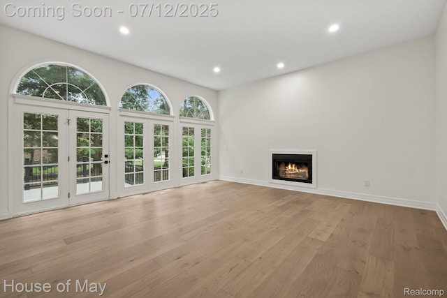 4743 S Ridge Dr, West Bloomfield, MI 48323 - unfurnished living room with recessed lighting, a glass covered fireplace, and light wood-style flooring