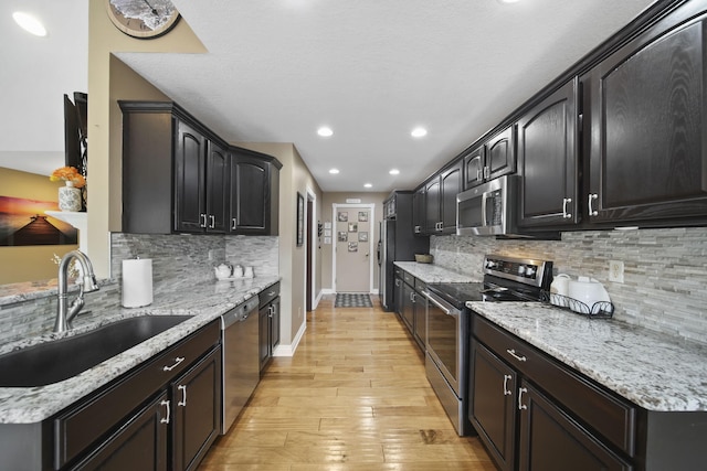 11259 Baker Rd, Jerome, MI 49249 - kitchen featuring appliances with stainless steel finishes, backsplash, light wood-style flooring, recessed lighting, and light stone counters