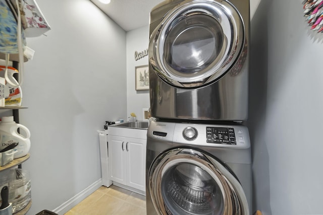 11259 Baker Rd, Jerome, MI 49249 - washroom with estacked washer and dryer, cabinet space, and light tile patterned floors