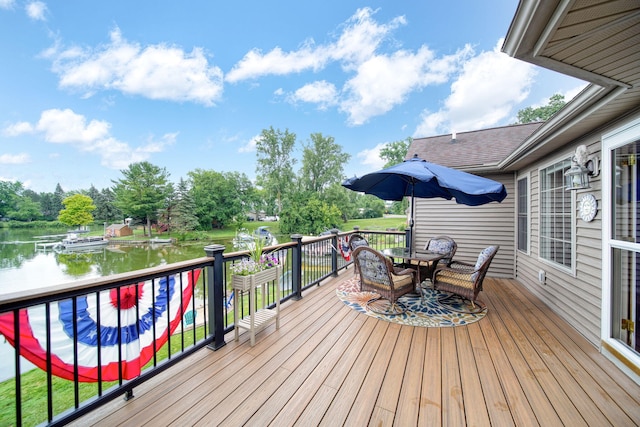 11259 Baker Rd, Jerome, MI 49249 - deck featuring a water view, outdoor dining area, and view of wooded area