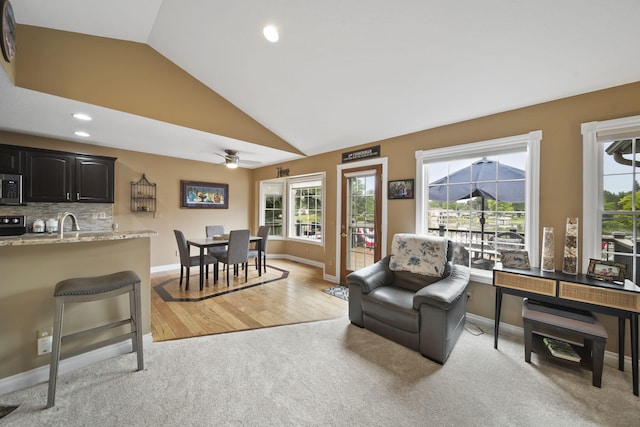 11259 Baker Rd, Jerome, MI 49249 - living area with light carpet, vaulted ceiling, plenty of natural light, a ceiling fan, and recessed lighting