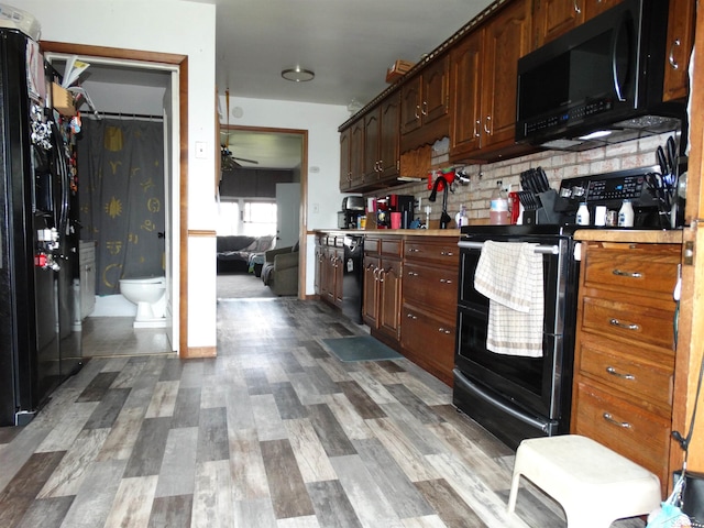 1570 Evon Rd, Saginaw, MI 48601 - kitchen with black appliances, ceiling fan, light countertops, backsplash, and wood finished floors
