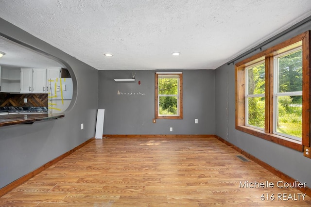 9583 E 5 Mile Rd, Big Rapids, MI 49307 - unfurnished living room featuring light wood-style flooring, a textured ceiling, and recessed lighting