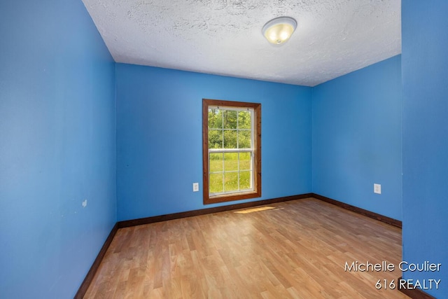 9583 E 5 Mile Rd, Big Rapids, MI 49307 - unfurnished room featuring a textured ceiling and wood finished floors