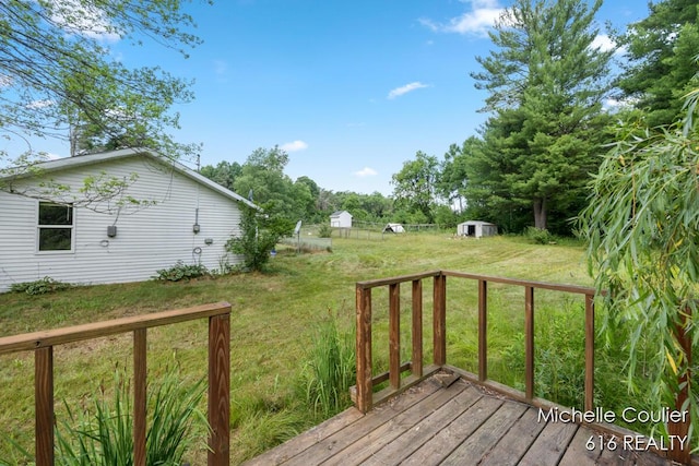 9583 E 5 Mile Rd, Big Rapids, MI 49307 - wooden deck with a lawn and a storage unit