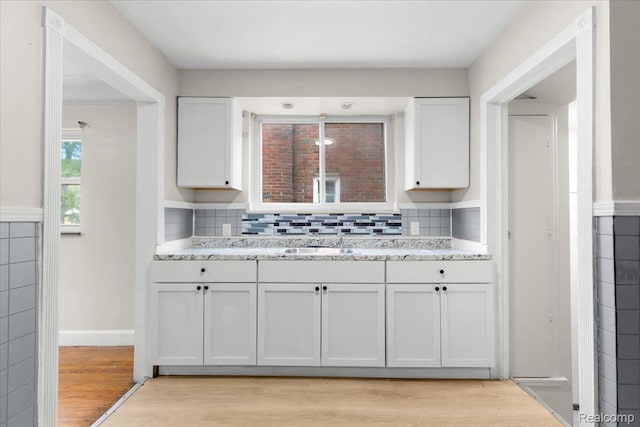 11110 Wayburn St, Grosse Pointe, MI 48224 - kitchen featuring light wood finished floors, white cabinetry, decorative backsplash, and light stone countertops