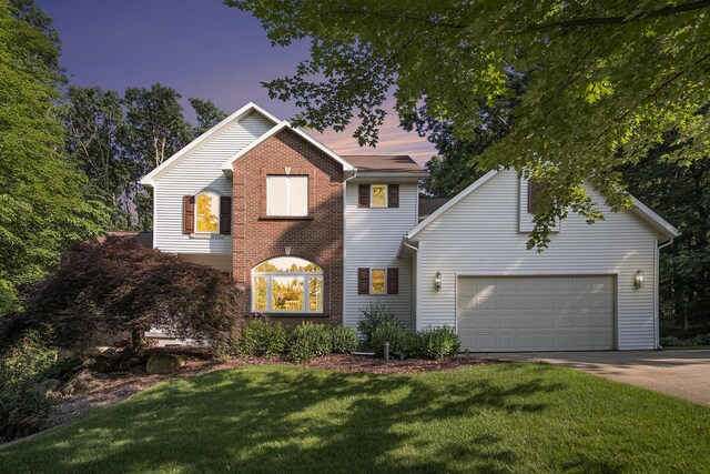 7751 Austinridge Dr SE, Caledonia, MI 49316 - traditional-style home featuring concrete driveway, a front lawn, an attached garage, and brick siding