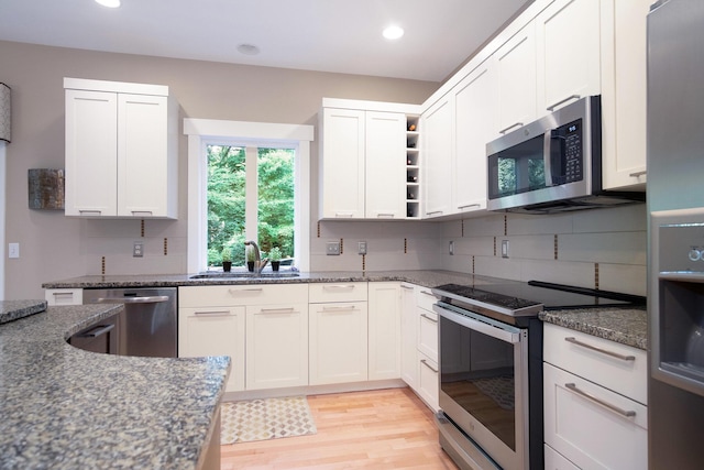 7751 Austinridge Dr SE, Caledonia, MI 49316 - kitchen with appliances with stainless steel finishes, tasteful backsplash, light wood-style flooring, open shelves, and recessed lighting