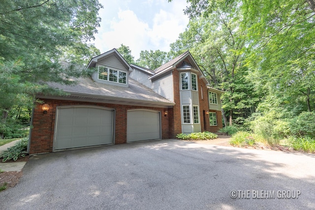 6340 Cannon Highlands Dr NE, Belmont, MI 49306 - view of front of home with asphalt driveway, brick siding, a garage, and roof with shingles