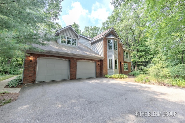 6340 Cannon Highlands Dr NE, Belmont, MI 49306 - view of front of house featuring driveway, brick siding, an attached garage, and a shingled roof