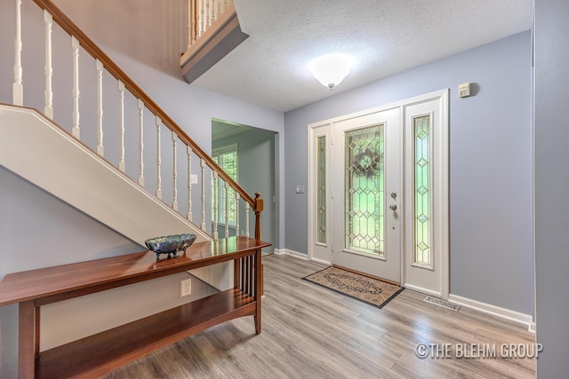 6340 Cannon Highlands Dr NE, Belmont, MI 49306 - entrance foyer with wood finished floors, stairway, and a textured ceiling
