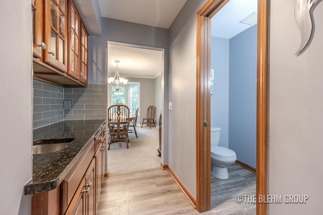 6340 Cannon Highlands Dr NE, Belmont, MI 49306 - hallway with light wood-style flooring, a chandelier, and crown molding