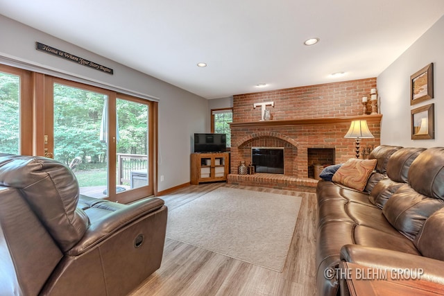 6340 Cannon Highlands Dr NE, Belmont, MI 49306 - living room with light wood-type flooring, a brick fireplace, and recessed lighting