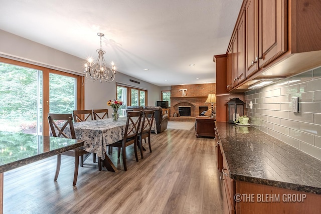 6340 Cannon Highlands Dr NE, Belmont, MI 49306 - dining room featuring a chandelier, light wood finished floors, a fireplace, and recessed lighting