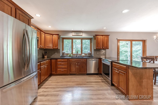 6340 Cannon Highlands Dr NE, Belmont, MI 49306 - kitchen with stainless steel appliances, a peninsula, healthy amount of natural light, brown cabinets, and recessed lighting