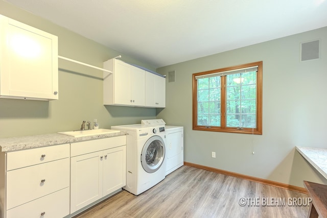 6340 Cannon Highlands Dr NE, Belmont, MI 49306 - laundry area featuring cabinet space, washer and clothes dryer, and light wood-style flooring