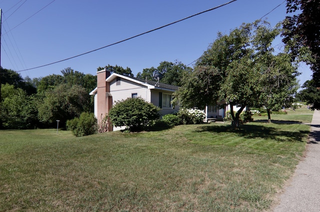 1340 Elmdale St NE, Grand Rapids, MI 49525 - view of home's exterior with a lawn and a chimney