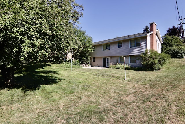 1340 Elmdale St NE, Grand Rapids, MI 49525 - rear view of property with a yard, a chimney, and a patio