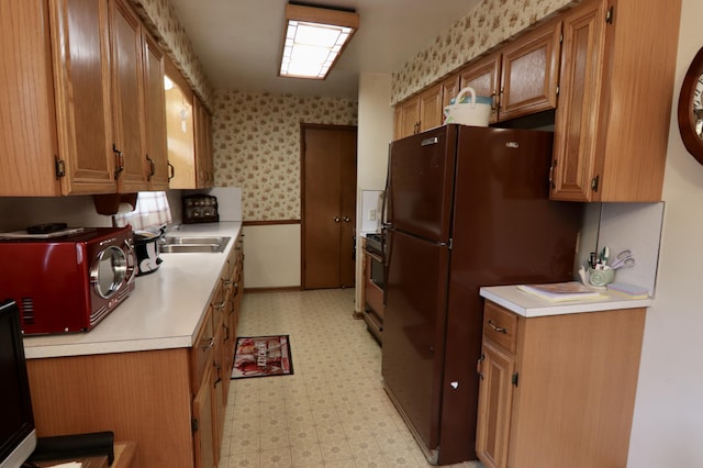 1340 Elmdale St NE, Grand Rapids, MI 49525 - kitchen featuring light flooring, light countertops, freestanding refrigerator, brown cabinets, and wallpapered walls