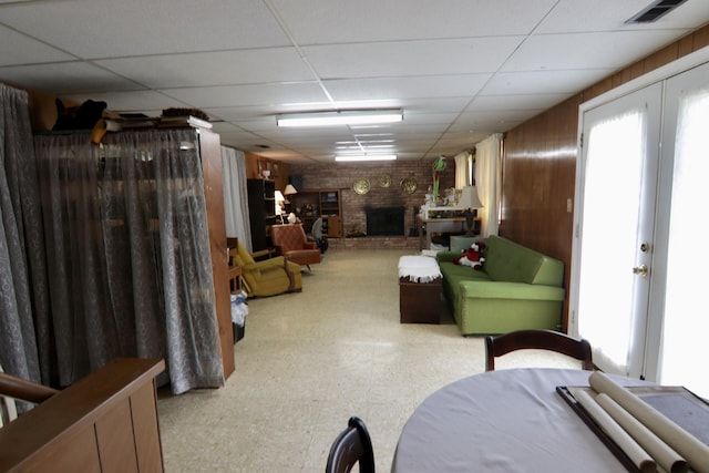 1340 Elmdale St NE, Grand Rapids, MI 49525 - below grade area with tile patterned floors, a paneled ceiling, a fireplace, wooden walls, and french doors
