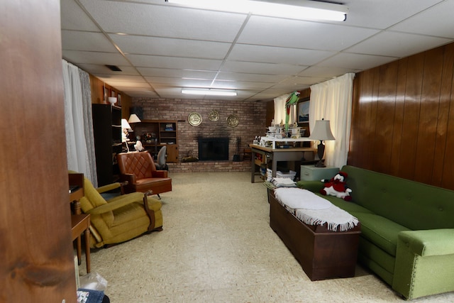 1340 Elmdale St NE, Grand Rapids, MI 49525 - living room featuring a drop ceiling, a brick fireplace, tile patterned floors, and wood walls