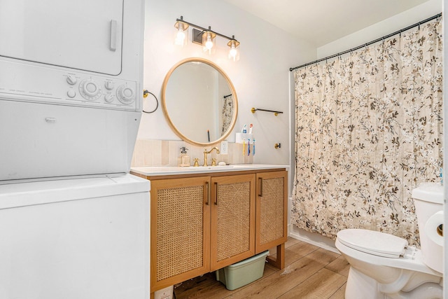 1213 Prospect Ave SE, Grand Rapids, MI 49507 - full bathroom featuring stacked washer and clothes dryer, wood finished floors, vanity, and a shower with curtain