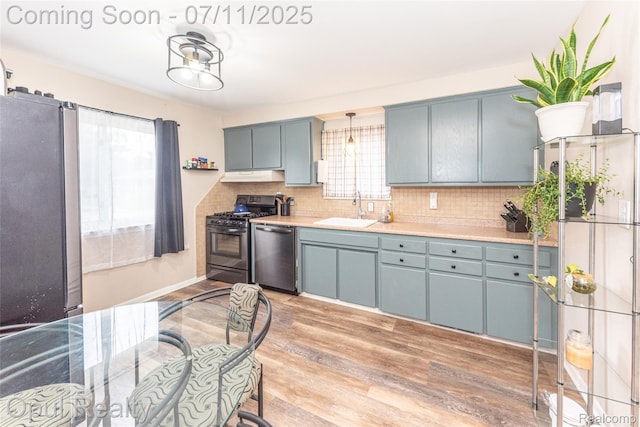 205 Shotka St, Westland, MI 48186 - kitchen with stainless steel appliances, tasteful backsplash, light wood-type flooring, light countertops, and under cabinet range hood