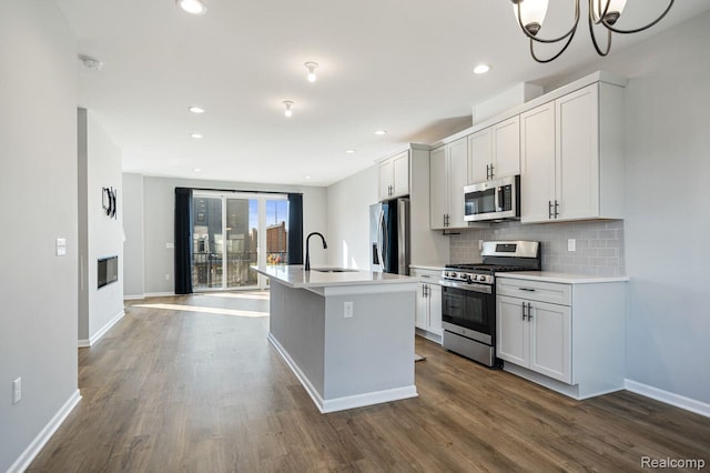1087 Hampton Cir Unit 55, Detroit, MI 48207 - kitchen featuring stainless steel appliances, a kitchen island with sink, dark wood finished floors, backsplash, and recessed lighting