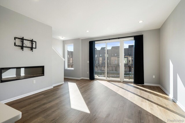 1087 Hampton Cir Unit 55, Detroit, MI 48207 - empty room featuring wood finished floors, recessed lighting, and a glass covered fireplace