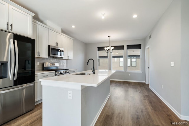 1087 Hampton Cir Unit 55, Detroit, MI 48207 - kitchen featuring appliances with stainless steel finishes, dark wood-style floors, a kitchen island with sink, backsplash, and recessed lighting