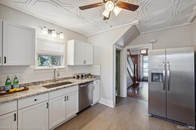 402 E 7th St, Royal Oak, MI 48067 - kitchen with appliances with stainless steel finishes, an ornate ceiling, decorative backsplash, white cabinetry, and light wood finished floors
