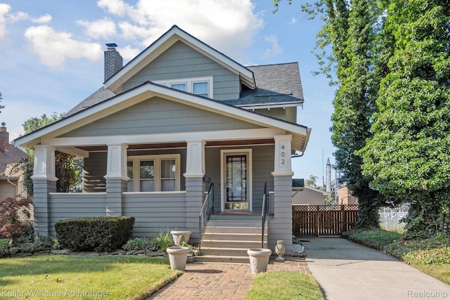 402 E 7th St, Royal Oak, MI 48067 - view of front of house featuring a shingled roof, a chimney, and a porch