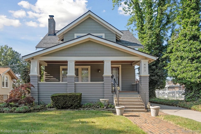 402 E 7th St, Royal Oak, MI 48067 - view of front of home featuring roof with shingles, a chimney, covered porch, and a front yard
