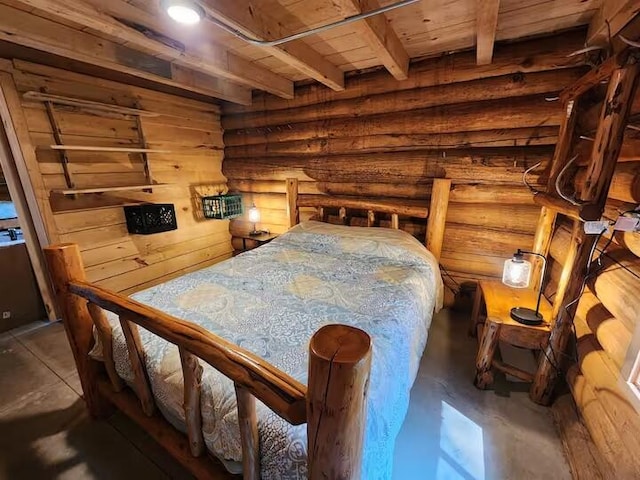 2599 N Pine Ave, White Cloud, MI 49349 - bedroom with a wooden ceiling with exposed beams, log walls, and concrete flooring