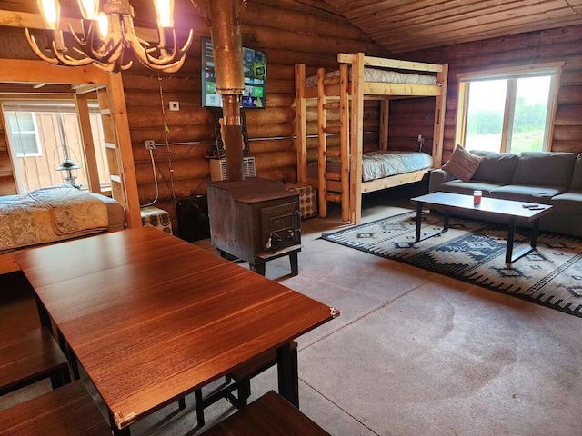 2599 N Pine Ave, White Cloud, MI 49349 - living area featuring log walls, a chandelier, wood ceiling, concrete flooring, and a wood stove