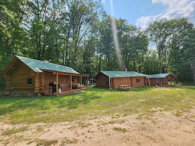 2599 N Pine Ave, White Cloud, MI 49349 - view of grassy yard with a porch and an outbuilding