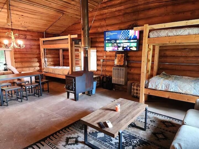 2599 N Pine Ave, White Cloud, MI 49349 - bedroom with rustic walls, finished concrete floors, a wood stove, a chandelier, and lofted ceiling