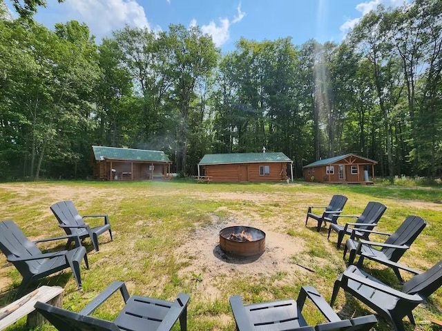 2599 N Pine Ave, White Cloud, MI 49349 - view of grassy yard with an outdoor fire pit and an outdoor structure