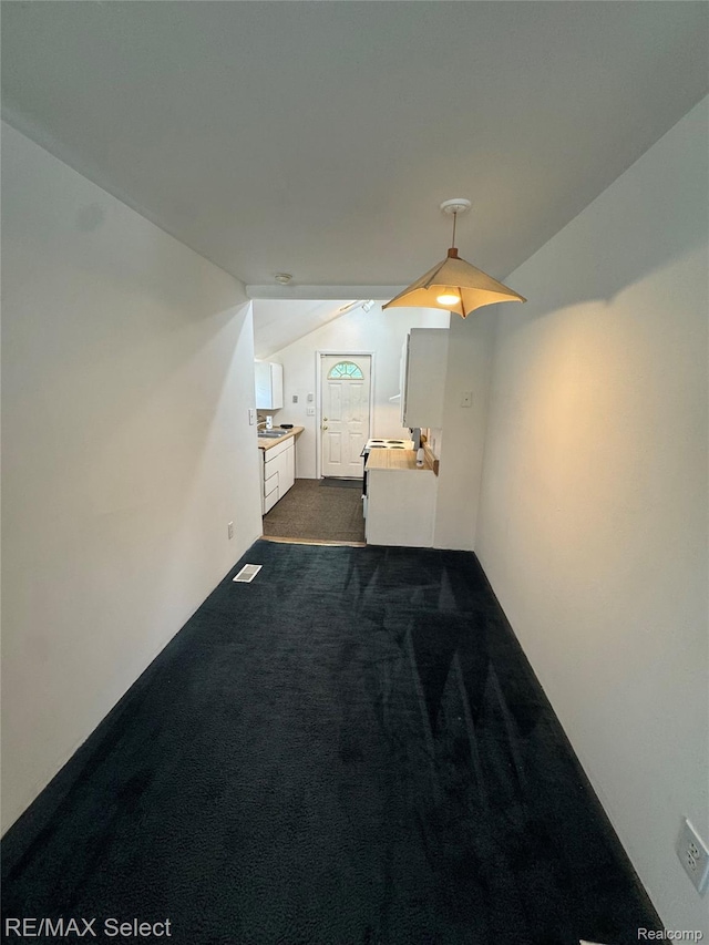 3605 Hogarth Ave, Flint, MI 48532 - hall with dark colored carpet and vaulted ceiling