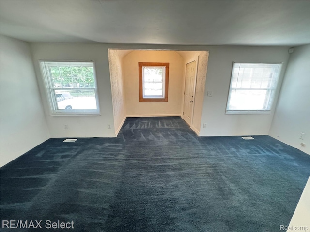 3605 Hogarth Ave, Flint, MI 48532 - empty room featuring dark colored carpet and healthy amount of natural light