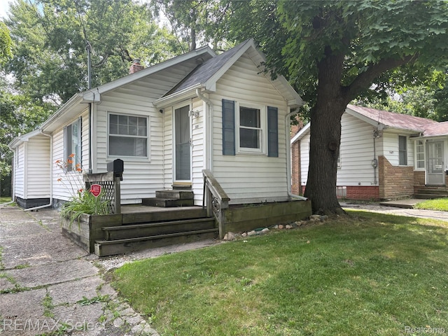 3605 Hogarth Ave, Flint, MI 48532 - bungalow-style home featuring a front yard, a chimney, and entry steps