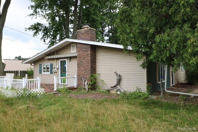 6048 N Lapeer Rd, Fostoria, MI 48435 - view of side of home with a chimney