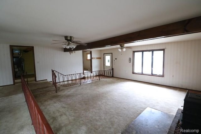 6048 N Lapeer Rd, Fostoria, MI 48435 - unfurnished living room featuring ceiling fan, carpet floors, and beam ceiling