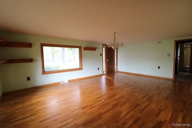 6048 N Lapeer Rd, Fostoria, MI 48435 - unfurnished living room with a chandelier and wood finished floors