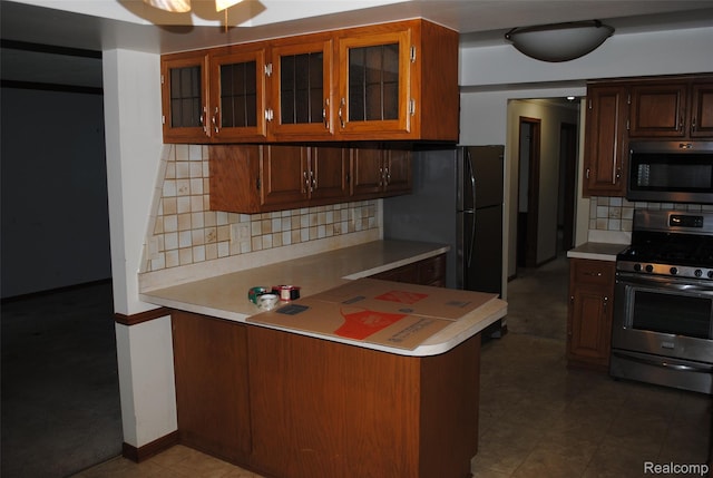 4785 Mayer Rd, China, MI 48054 - kitchen featuring gas range, light countertops, a peninsula, and decorative backsplash