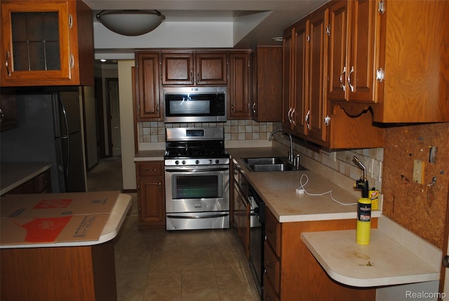 4785 Mayer Rd, China, MI 48054 - kitchen with appliances with stainless steel finishes, decorative backsplash, light countertops, dark tile patterned floors, and brown cabinetry